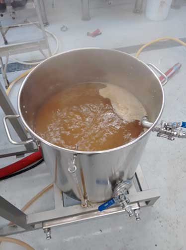 Bring the wort up to a boil. We add our hops over the next hour.